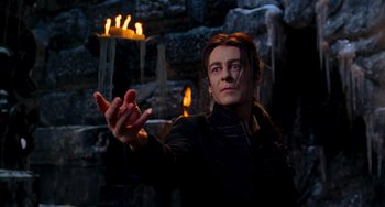 Movie still from “Van Helsing” (2004), directed by Stephen Sommers – A man in a black jacket is holding his hands out; Medium shot, Low angle