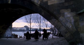 Movie still from “Van Helsing” (2004), directed by Stephen Sommers – A group of people sitting on a bench under a bridge; Extreme Wide shot, High angle