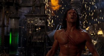 Movie still from “Van Helsing” (2004), directed by Stephen Sommers – A shirtless man with long black hair is in the dark; Medium shot, Low angle