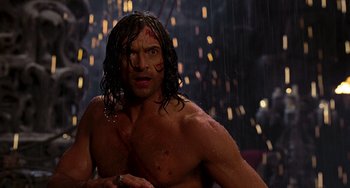 Movie still from “Van Helsing” (2004), directed by Stephen Sommers – A shirtless man in the rain looking at the camera; Medium shot, Over the shoulder angle