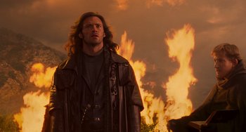 Movie still from “Van Helsing” (2004), directed by Stephen Sommers – A man standing in front of a burning fire; Medium shot, Over the shoulder angle