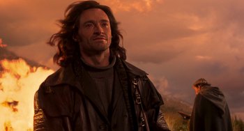 Movie still from “Van Helsing” (2004), directed by Stephen Sommers – A man with long brown hair standing in front of a sunset; Close Up shot, Low angle