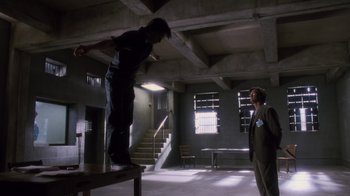 Movie still from “Vanilla Sky” (2001), directed by Cameron Crowe – A man riding a skateboard on top of a wooden platform; Wide shot, Low angle