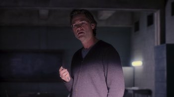 Movie still from “Vanilla Sky” (2001), directed by Cameron Crowe – A man with glasses is standing in a dark room; Medium shot, Low angle