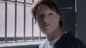 Movie still from “Vanilla Sky” (2001), directed by Cameron Crowe – A man with a mask on his face is sitting in front of a window; Close Up shot, Low angle
