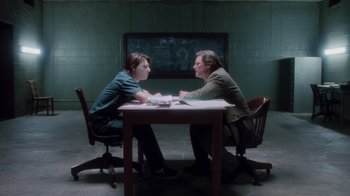 Movie still from “Vanilla Sky” (2001), directed by Cameron Crowe – Two people sitting at a table in front of a chalkboard; Wide shot, Over the shoulder angle