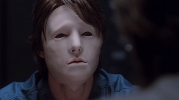 Movie still from “Vanilla Sky” (2001), directed by Cameron Crowe – A man with a mask on his face is sitting down; Close Up shot, Over the shoulder angle