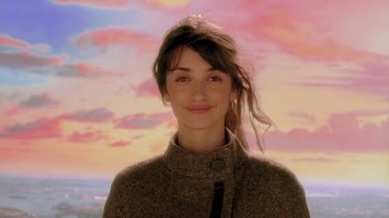 Movie still from “Vanilla Sky” (2001), directed by Cameron Crowe – A woman in a brown jacket is smiling for the camera; Close Up shot, Low angle