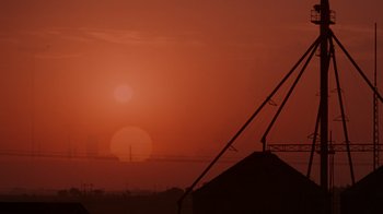 Movie still from “Varsity Blues” (1999), directed by Brian Robbins – The sun is setting over the ocean and the sky is red; Extreme Wide shot, Low angle