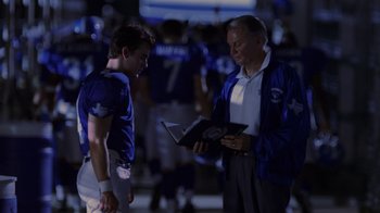 Movie still from “Varsity Blues” (1999), directed by Brian Robbins – A football player and a coach talking to each other; Medium shot, Over the shoulder angle