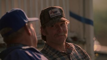 Movie still from “Varsity Blues” (1999), directed by Brian Robbins – A man wearing a hat and a plaid shirt; Close Up shot, Over the shoulder angle