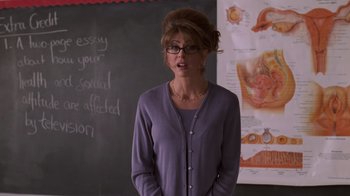 Movie still from “Varsity Blues” (1999), directed by Brian Robbins – A woman standing in front of a chalkboard; Medium shot, Over the shoulder angle