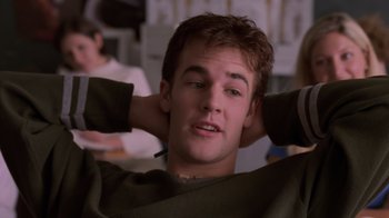 Movie still from “Varsity Blues” (1999), directed by Brian Robbins – A young man sitting down with his hands behind his head; Close Up shot, Over the shoulder angle
