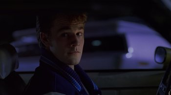 Movie still from “Varsity Blues” (1999), directed by Brian Robbins – A young man in a blue jacket is looking at the camera; Close Up shot, Over the shoulder angle