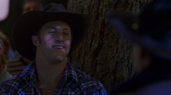Movie still from “Varsity Blues” (1999), directed by Brian Robbins – A man wearing a cowboy hat and a plaid shirt; Close Up shot, Over the shoulder angle