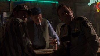 Movie still from “Varsity Blues” (1999), directed by Brian Robbins – A group of men sitting at a table with a beer; Medium shot, Over the shoulder angle