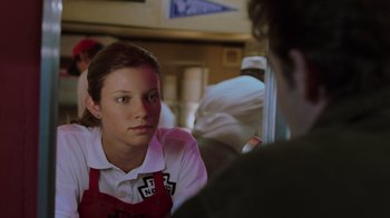 Movie still from “Varsity Blues” (1999), directed by Brian Robbins – A woman sitting in front of a man in front of a window; Close Up shot, Over the shoulder angle