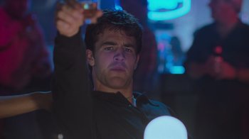 Movie still from “Varsity Blues” (1999), directed by Brian Robbins – A man holding a glass in his right hand; Close Up shot, Low angle
