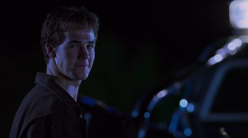 Movie still from “Varsity Blues” (1999), directed by Brian Robbins – A man standing in front of a car at night; Close Up shot, Over the shoulder angle