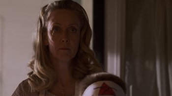 Movie still from “Varsity Blues” (1999), directed by Brian Robbins – A woman looking into a mirror while holding a ball in her hand; Close Up shot, Low angle