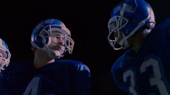 Movie still from “Varsity Blues” (1999), directed by Brian Robbins – A couple of men wearing football uniforms and helmets; Close Up shot, Over the shoulder angle
