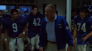 Movie still from “Varsity Blues” (1999), directed by Brian Robbins – A group of men standing next to each other in a room; Medium shot, Over the shoulder angle