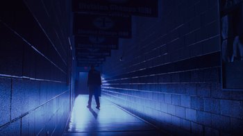 Movie still from “Varsity Blues” (1999), directed by Brian Robbins – A man is standing in a dark tunnel; Wide shot, Low angle