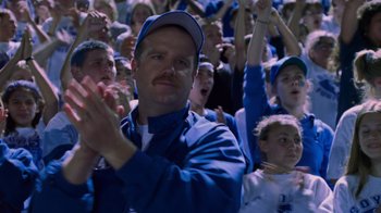 Movie still from “Varsity Blues” (1999), directed by Brian Robbins – A crowd of people in a stadium clapping; Medium shot, Over the shoulder angle