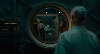 Movie still from “Venom: Let There Be Carnage” (2021), directed by Andy Serkis – A group of people standing in a room with a mirror; Wide shot, Over the shoulder angle