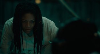 Movie still from “Venom: Let There Be Carnage” (2021), directed by Andy Serkis – A man with dreads sitting in front of a laptop computer; Close Up shot, Over the shoulder angle