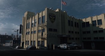 Movie still from “Venom: Let There Be Carnage” (2021), directed by Andy Serkis – A building with a police car parked in front of it; Extreme Wide shot, Low angle