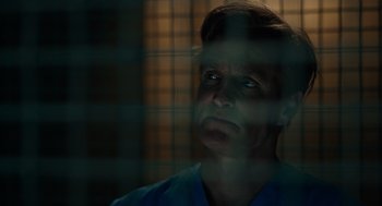 Movie still from “Venom: Let There Be Carnage” (2021), directed by Andy Serkis – A man in a blue shirt looking out of a window; Close Up shot, Low angle