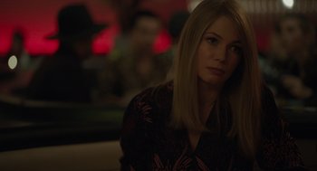 Movie still from “Venom: Let There Be Carnage” (2021), directed by Andy Serkis – A woman sitting at a table in front of a red light; Close Up shot, Over the shoulder angle