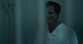 Movie still from “Venom: Let There Be Carnage” (2021), directed by Andy Serkis – A man wearing a white shirt is looking at the camera through a window; Close Up shot, Over the shoulder angle