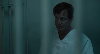 Movie still from “Venom: Let There Be Carnage” (2021), directed by Andy Serkis – A man wearing a white robe in a room; Close Up shot, High angle