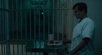 Movie still from “Venom: Let There Be Carnage” (2021), directed by Andy Serkis – A man standing in front of a table holding a tray of food; Medium shot, High angle