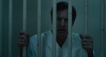 Movie still from “Venom: Let There Be Carnage” (2021), directed by Andy Serkis – A man behind bars in a jail cell; Close Up shot, Low angle