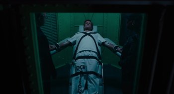 Movie still from “Venom: Let There Be Carnage” (2021), directed by Andy Serkis – A man is strapped to a bed in a room with green walls; Wide shot, High angle