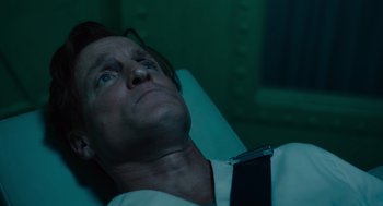 Movie still from “Venom: Let There Be Carnage” (2021), directed by Andy Serkis – A man in a white dress shirt and a black tie laying in a chair; Close Up shot, High angle