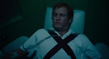 Movie still from “Venom: Let There Be Carnage” (2021), directed by Andy Serkis – A man in white shirt and black tie sitting in a chair; Medium shot, High angle