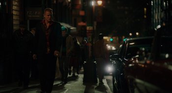 Movie still from “Venom: Let There Be Carnage” (2021), directed by Andy Serkis – A group of people walking down a sidewalk at night; Wide shot, Low angle