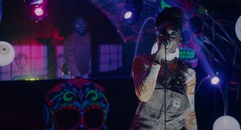 Movie still from “Venom: Let There Be Carnage” (2021), directed by Andy Serkis – A man with a microphone in front of a crowd of onlookers; Medium shot, Low angle