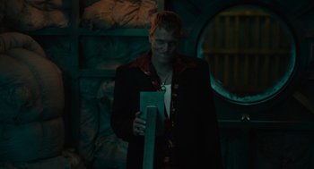 Movie still from “Venom: Let There Be Carnage” (2021), directed by Andy Serkis – A man in a black jacket holding a piece of paper; Medium shot, Low angle