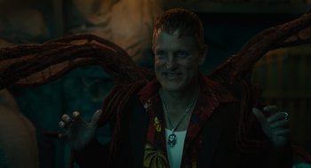 Movie still from “Venom: Let There Be Carnage” (2021), directed by Andy Serkis – A man in a red jacket and a necklace; Close Up shot, Low angle