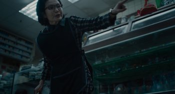 Movie still from “Venom: Let There Be Carnage” (2021), directed by Andy Serkis – An older woman pointing at something in a store; Medium shot, Low angle