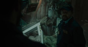 Movie still from “Venom: Let There Be Carnage” (2021), directed by Andy Serkis – A man in a police uniform standing next to another man in military fatigues; Medium shot, Over the shoulder angle