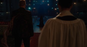 Movie still from “Venom: Let There Be Carnage” (2021), directed by Andy Serkis – Two men standing in front of a woman in a black dress; Extreme Wide shot, Over the shoulder angle