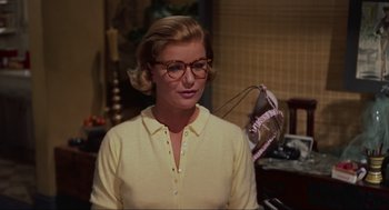 Movie still from “Vertigo” (1958), directed by Alfred Hitchcock – A woman wearing glasses standing in front of a mirror; Close Up shot, Over the shoulder angle