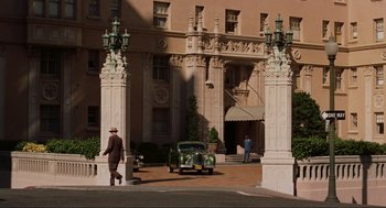 Movie still from “Vertigo” (1958), directed by Alfred Hitchcock – A man walking down the street in front of a building; Wide shot, Low angle