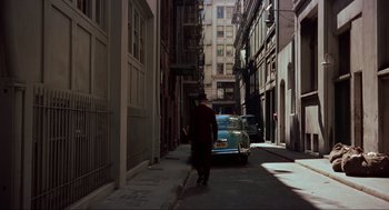 Movie still from “Vertigo” (1958), directed by Alfred Hitchcock – A man walking down the street with a cane; Extreme Wide shot, High angle